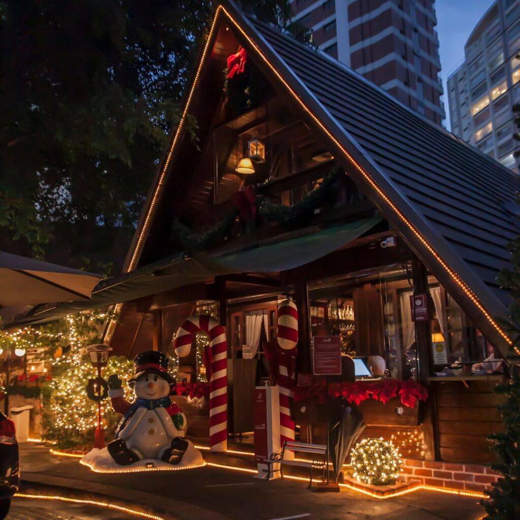 Fachada do chalé decorada com bengalas de Natal e boneco de neve